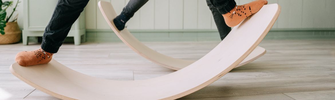 two boys balancing on wooden balance boards