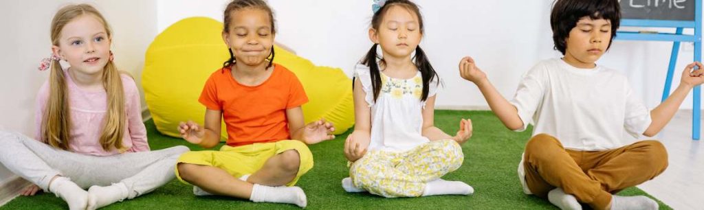 Occupational Therapy in Truro Cornwall Children seated on the floor practicing yoga. occupational therapist Cornwall and Devon