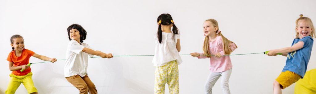 a picture of five children pulling a rope and playing tug 'o' war