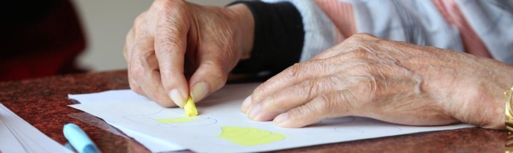 elderly lady colouring in a picture. Developing her fine motor skills.