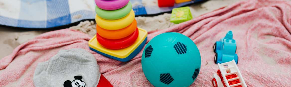 baby toys on a mat on a beach