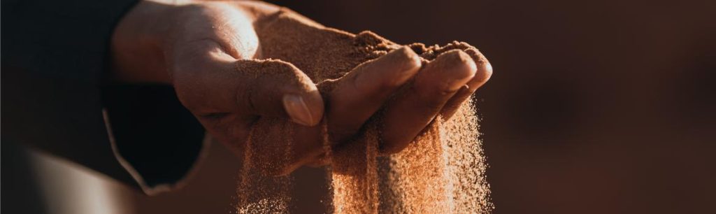 a person sifting sand through their fingers