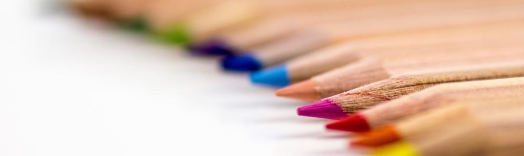 coloured pencils laid out on a white surface