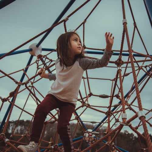 girl climbing on a climbing frame. Proprioceptive Activities.